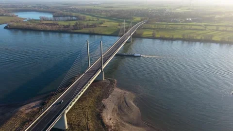 Aerial view of a cable stayed bridge over a wide river, with a large cargo Stock-Footage 329811173