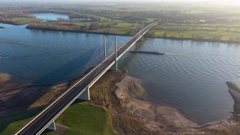 Aerial view of a cable stayed bridge over a wide river, with a large cargo Видео 331851935