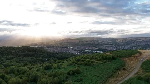 Aerial View of Caerphilly Mountain with Low Sun Through Clouds Stock Footage 343577507