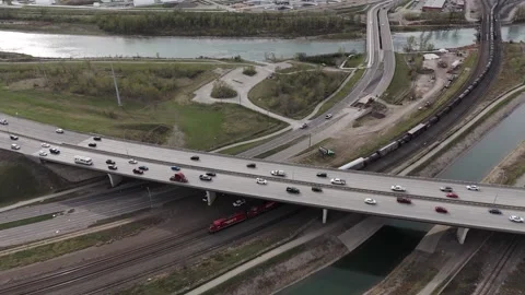 Aerial View of Calgary Transportation Infrastructure; a Train, Highway and River Видео 337088268