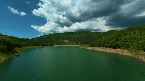 Aerial view of a calm lake surrounded by forested hills. Zavoj Lake, Serbia Stock Footage 337491668