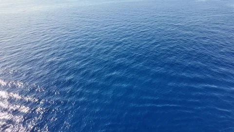 Aerial View of Calm Ocean with Soft Ripples and Light Reflection under a Clear B Stock Footage 283547973
