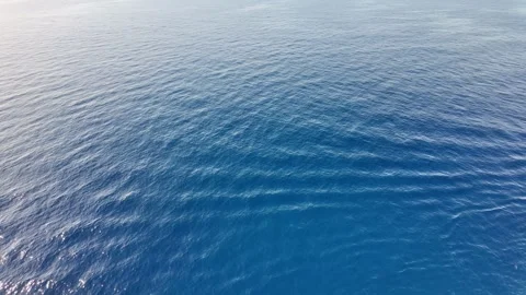 Aerial View of Calm Ocean with Soft Ripples and Light Reflection under a Clear B Stock Footage 283547974