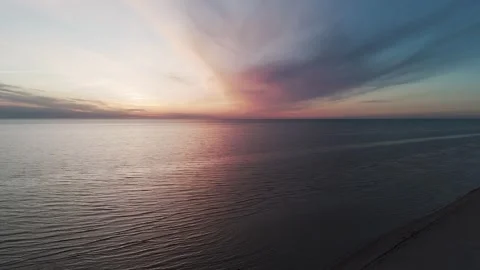 Aerial view of calm sea waves reaching empty beach at scenic pink sunset sky. Stock Footage 337786353