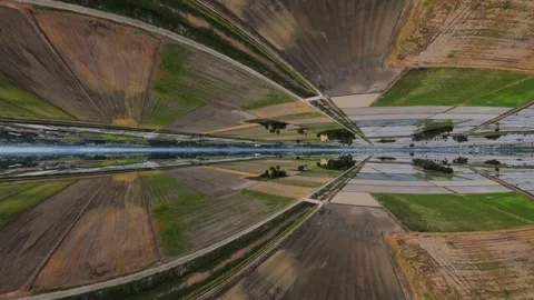 Aerial view of calm waters reflecting farmland Видео 345397437