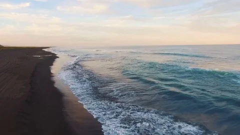 Aerial view. The camera flies straight to the sea. Sun at sunset shining into Stock Footage 72738008