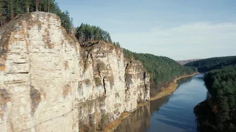 Aerial view; camera moving along rocky cliff of river Stock Footage 117995061