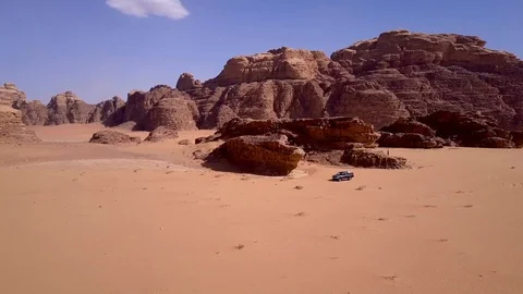 Aerial view of a camera moving toward a car in the desert Stock Footage 103210694