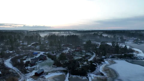 Aerial view camera panning over small coastal scandinavian villag in snow Stock Footage 296486726