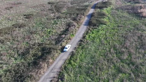 Aerial View of a Camper Van on a Dirt Road in a Grassy Field Stock Footage 341979786