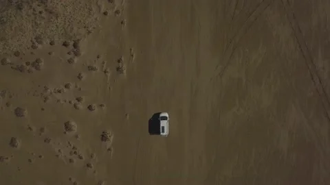 Aerial view of a camper van driving along a sandy beach on a summer day Stock Footage 159440144