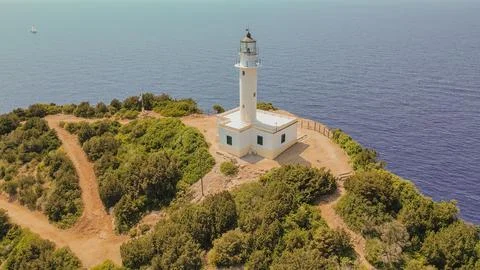 Aerial view of Cape Doukato lighthouse on steep rocky cliff surrounded by b.. Stock Photos