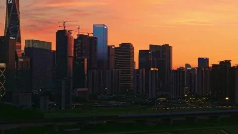 Aerial view captures bright orange sunset glows over the tall modern buildings Stock-Footage 341837018