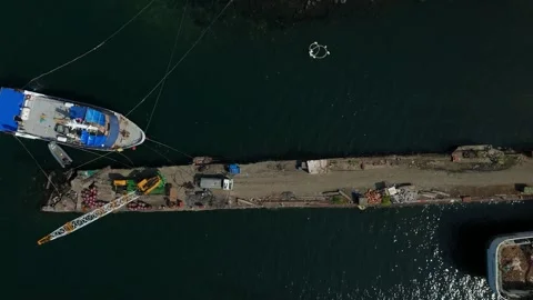 Aerial view captures a bustling dock with boats and a floating platform. 스톡 동영상 335581503