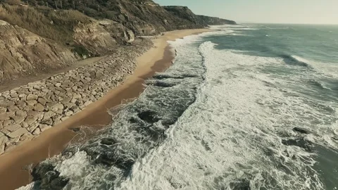 Aerial view captures crashing waves on sandy shores Stock Footage 341825409