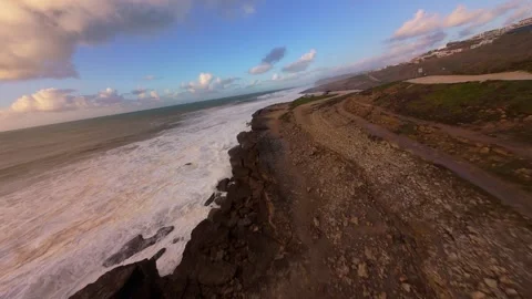 Aerial view captures dramatic ocean waves crashing against rugged cliffs Stock Footage 344550359