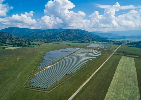 Aerial view captures an extensive solar farm installation spans a verdant v.. Stock Photos