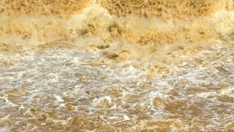 Aerial view captures fast moving muddy floodwater. Video stock 346359757