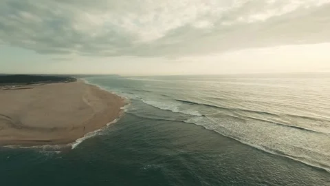 Aerial view captures gentle waves lapping a wide sandy beach Stock Footage 340227270