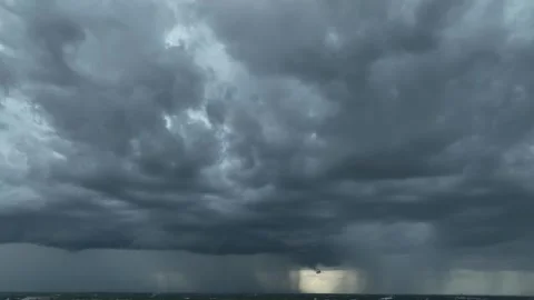 Aerial view captures heavy rain beneath dark gray storm clouds. Stock Footage 345428316
