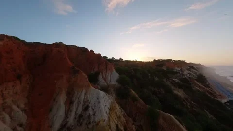 Aerial view captures layered cliffs meeting ocean at sunset Video stock 346090138