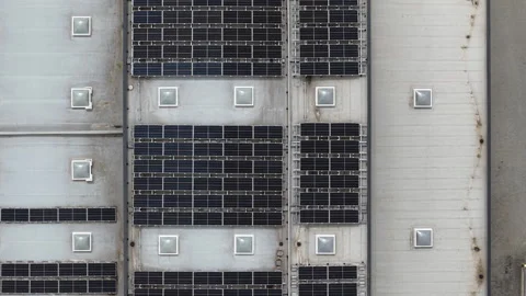 An aerial view captures numerous solar panels arranged on a commercial Vídeos de archivo 336383069
