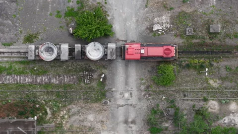 An aerial view captures a red industrial train with large cargo wagons on Stock Footage 337470307