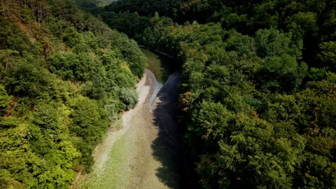 An aerial view captures a river with significantly reduced water levels flowing Stock Footage 342210708