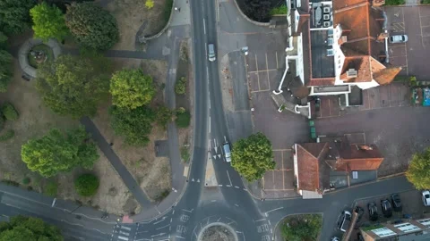 An aerial view captures a road intersection with a roundabout. Cars navigat.. Stock Footage 340522229