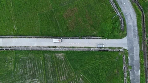 Aerial view captures a road through lush green fields. Stock Footage 336023829