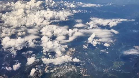 An aerial view captures a stunning cloud formation draping over majestic Stock Photos