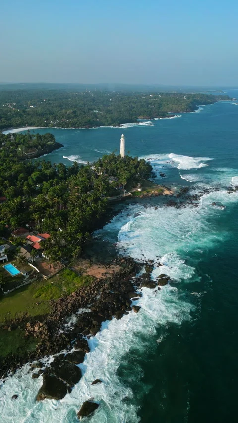 Aerial view captures towering lighthouse overlooking tropical lagoon with foamy Stock Footage 270423780