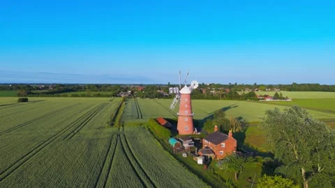 Aerial view captures a traditional windmill amid green fields 库存影片 342609815