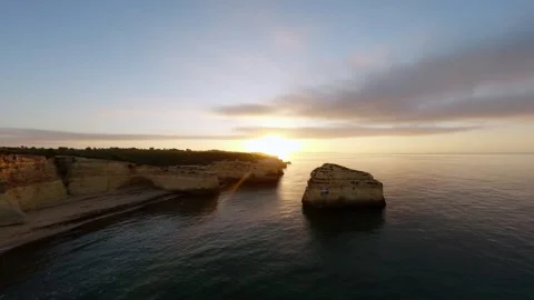 Aerial view captures tranquil coastline at dusk with warm sun rays Video stock 346091408