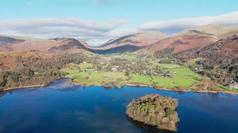 An aerial view captures a tranquil lake scene, nestled among rolling hills. Stock Footage 293798595