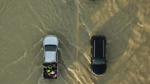 Aerial view captures vehicles surrounded by muddy floodwater. Vídeo Stock 347722339