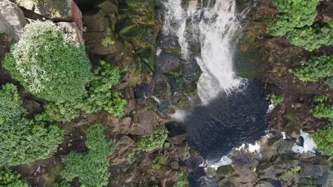 Aerial view captures waterfall crashing onto mossy rocks Видео 342934184