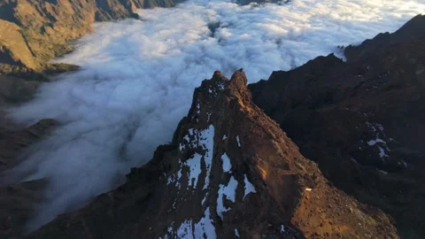 Aerial view capturing Roque de los Muchachos peak rising through misty clouds Stock Footage 308587671