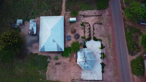 Aerial view capturing a rural compound with buildings and vegetation in daylight Stock Footage 318394464