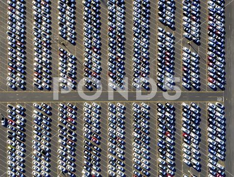 Aerial view of a car distribution centre, new cars parked in rows on a lot ready Stock Photos