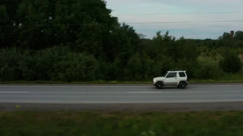 Aerial view of a car driving along the road among fields of green grass Stock Footage 166350485