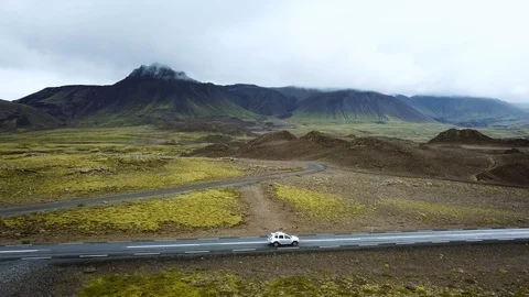 Aerial view of car driving on asphalt road in Iceland, profile follow Stock Footage 98123775