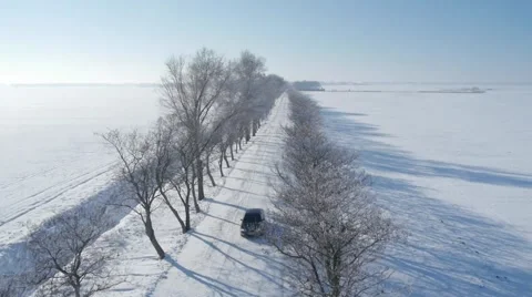 Aerial view of a car driving on the empty snowy road. Stock Footage 46813519
