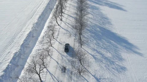 Aerial view of a car driving on the empty snowy road. Stock Footage 46814686