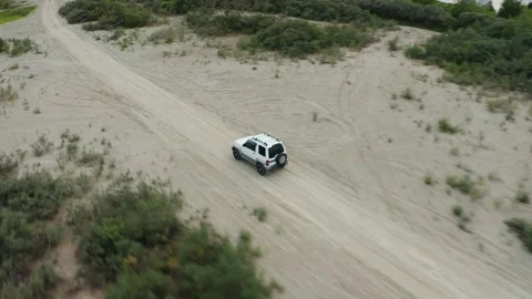 Aerial view of a car driving on sand Stock Footage 167166144
