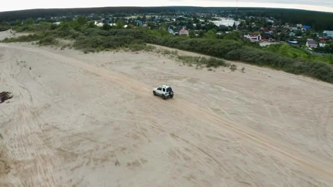 Aerial view of a car driving on sand Stock Footage 167166174