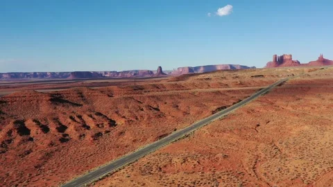 Aerial view of a car driving on State Route 163 in Utah toward Monument Valley Stock Footage 229518595