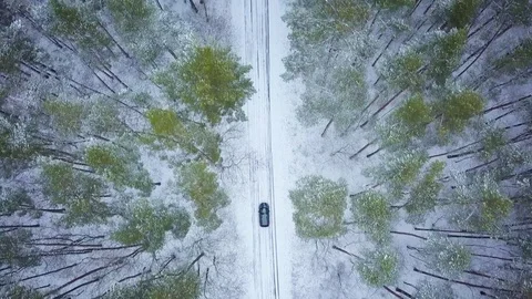 Aerial view on car driving through winter forest road. Scenic winter landscape Stock Footage 83297467
