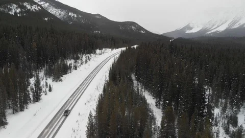 Aerial View of a Car Driving Through the Icefields Parkway in Winter Stock Footage 87198796