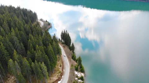 Aerial view of car driving through the mountain forest and the lake on the side Video stock 150664381